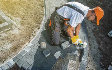 Arbeiter verlegt Steinweg bei Erdbau Holzinger-Gruber in Amstetten