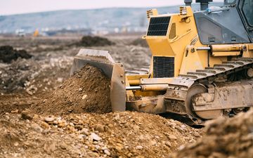 Durchführung von Erdbauarbeiten mit gelbem Bagger bei Erdbau Holzinger-Gruber in Amstetten